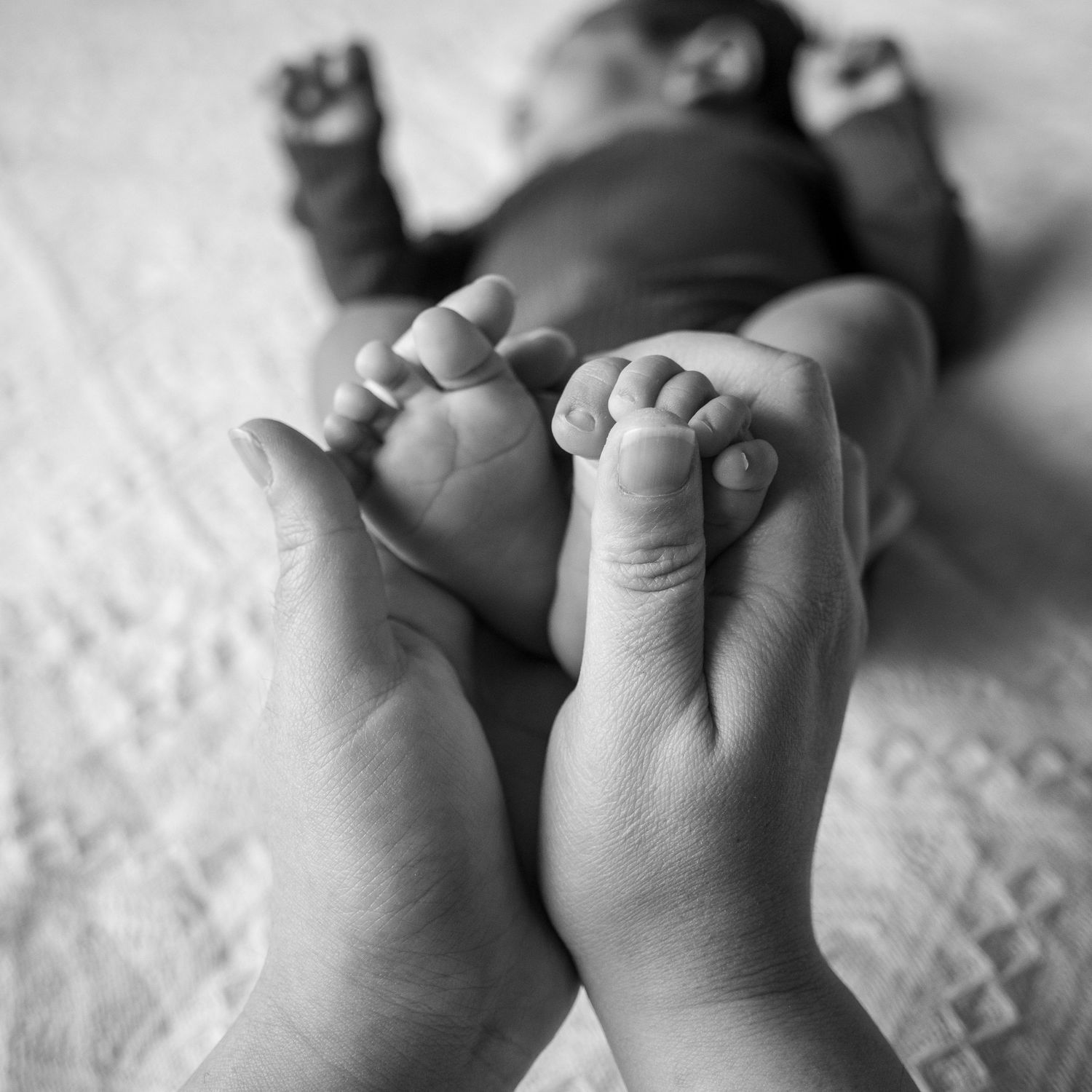 Mother holding newborn feet in shape of heart