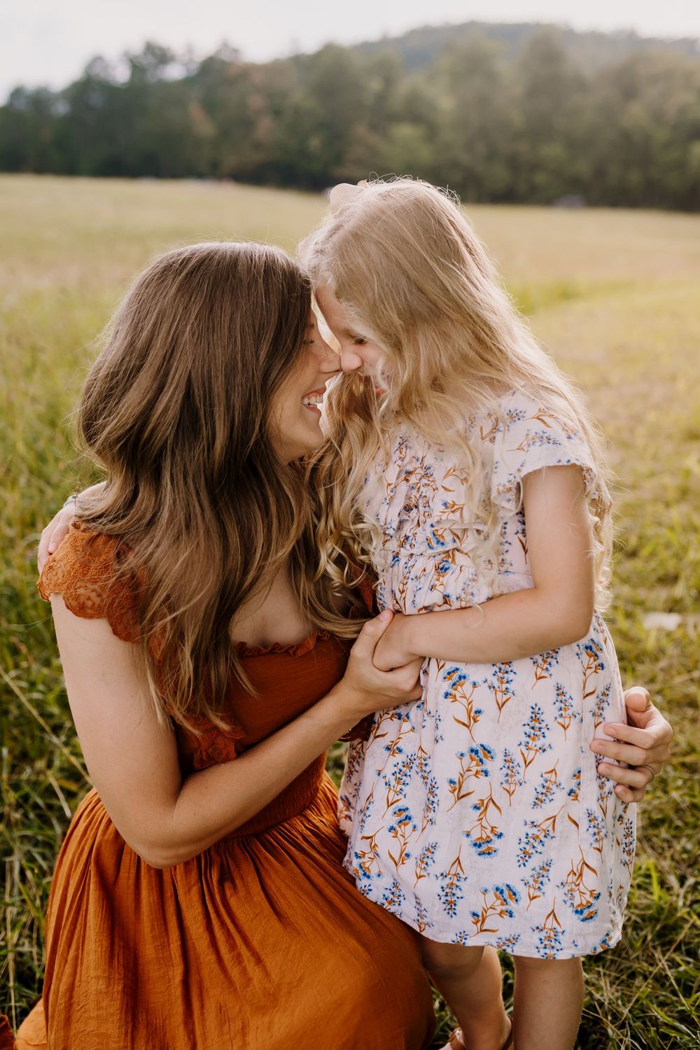 Mom and daughter snuggle during golden hour photos