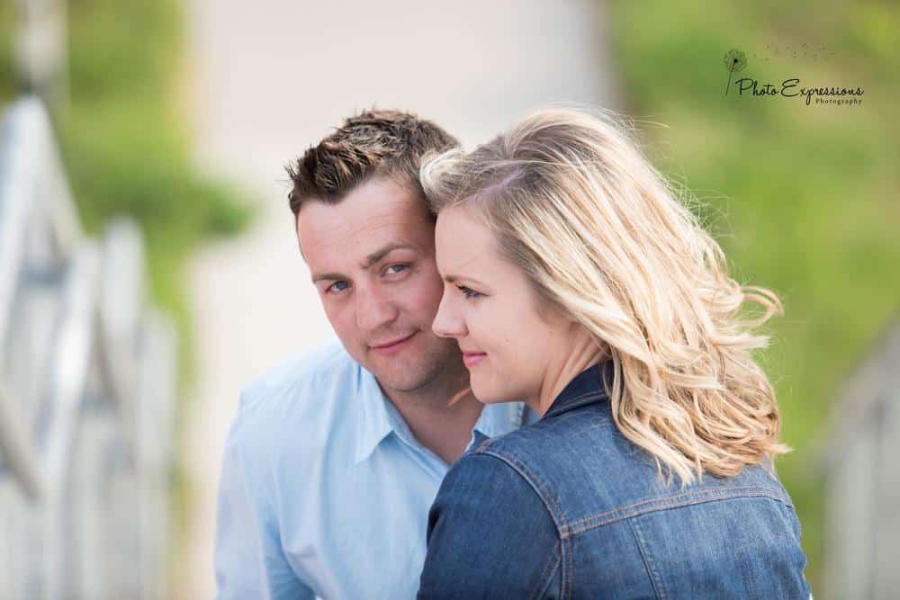 Romantic couple shares tender moments in a park setting with soft natural lighting.