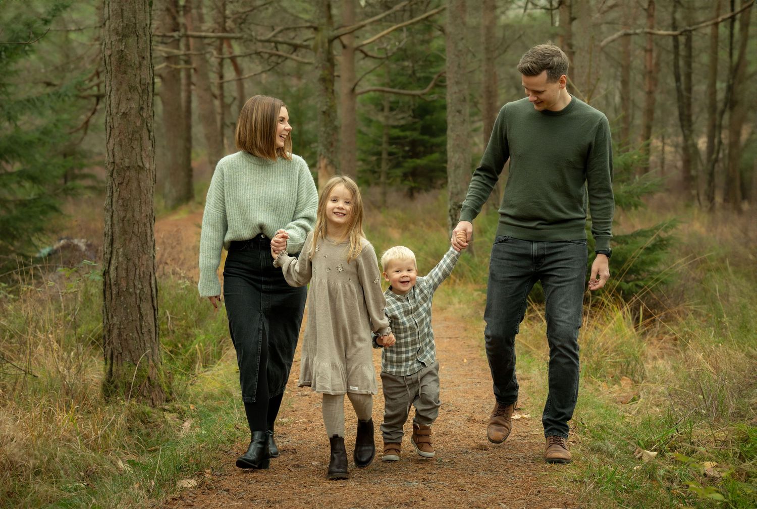 Familiefotografering i Sandnes, familie på fire går sammen i naturlige omgivelser