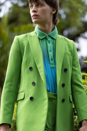 Close-up of bright green double-breasted blazer with turquoise polo shirt.