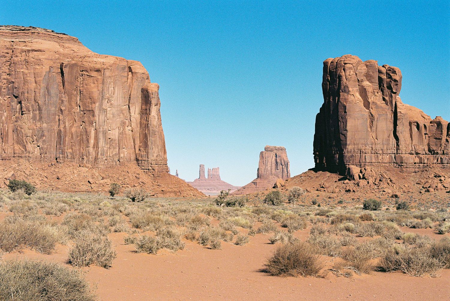 Panoramic view of red rock formations and desert landscape in Monument Valley.