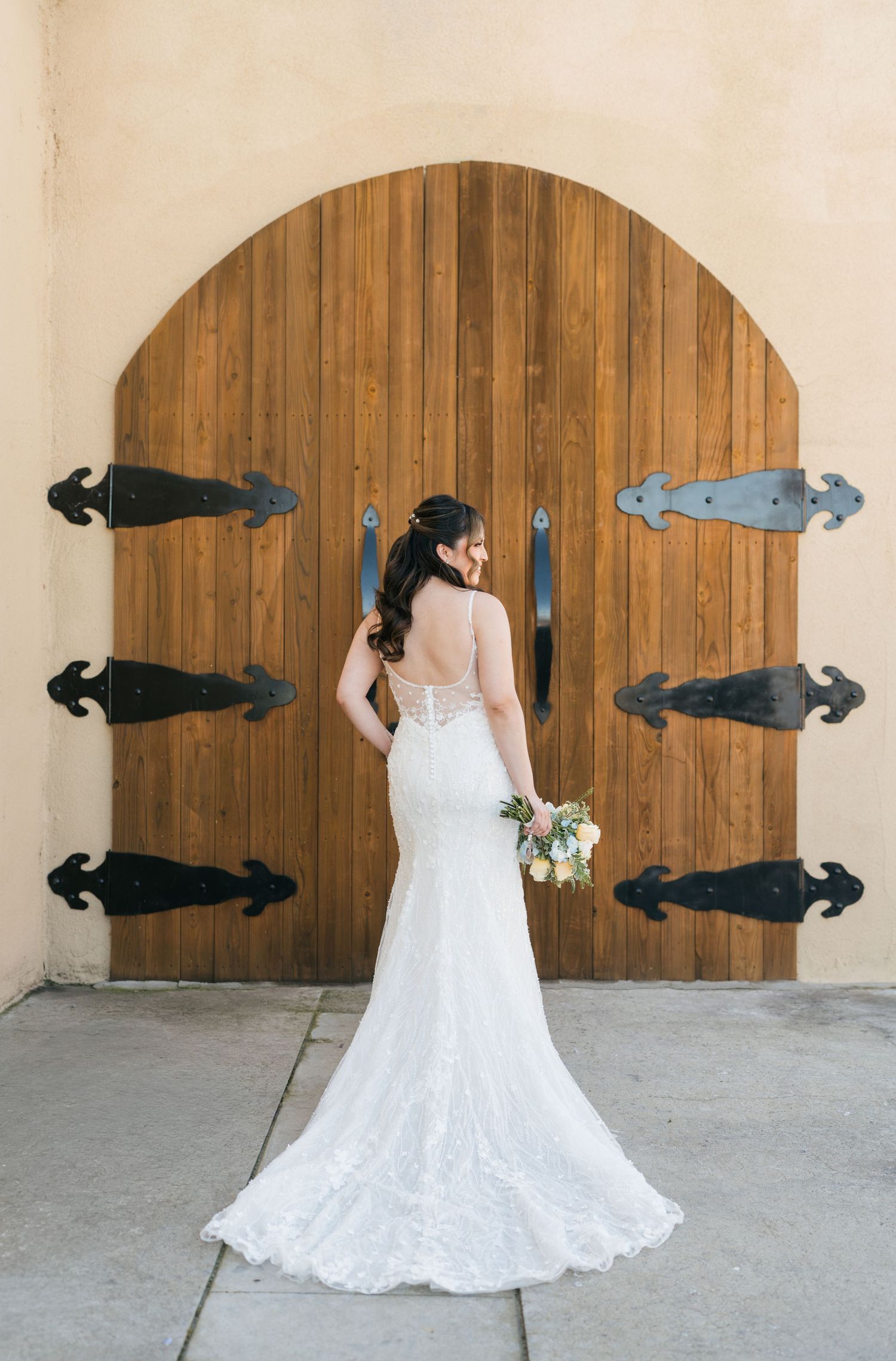 A creative wedding photo series showing a bride in a lace gown with groomsmen lying horizontally on a curved wooden wall.