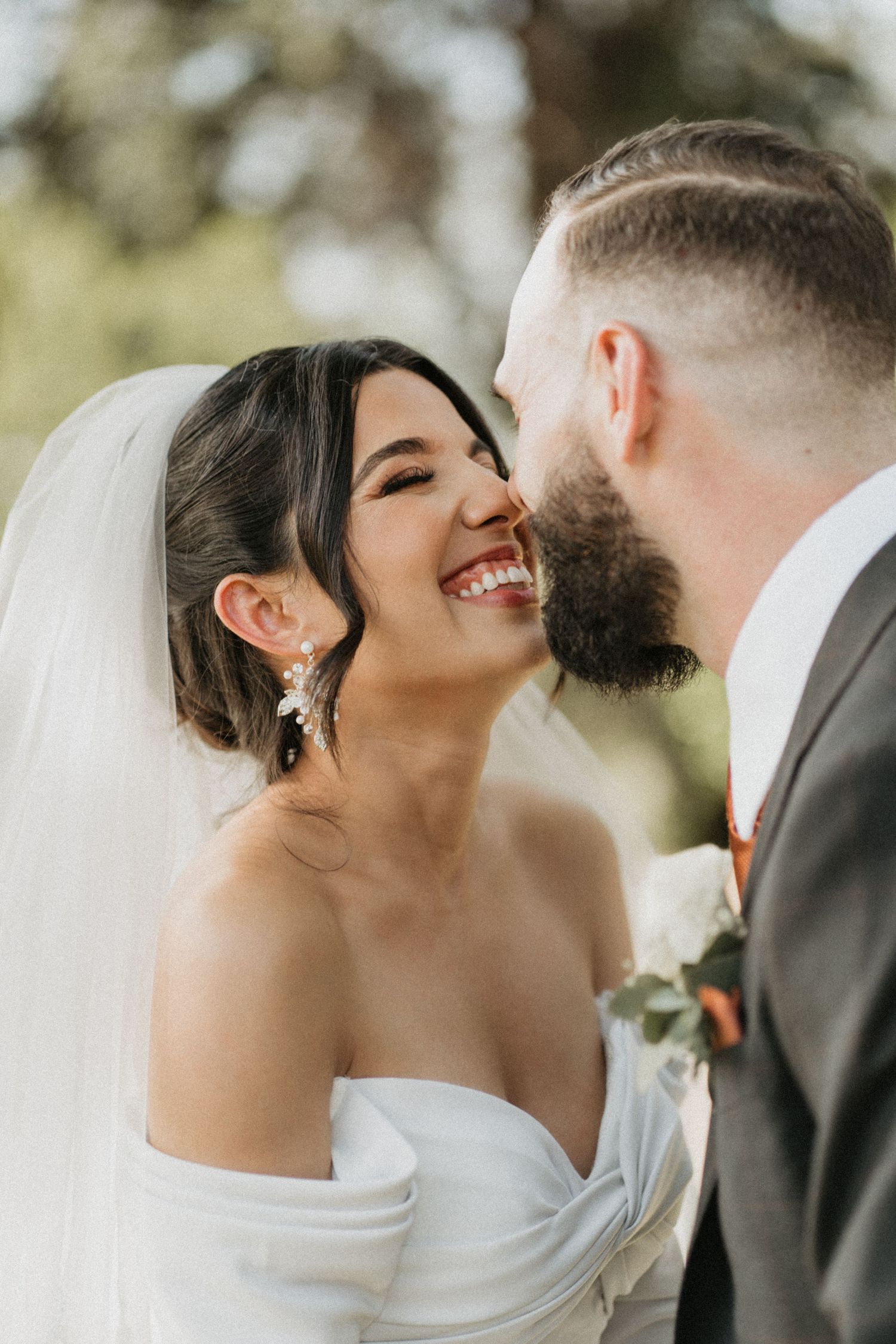 Intimate wedding portrait capturing genuine laughter between bride and groom.