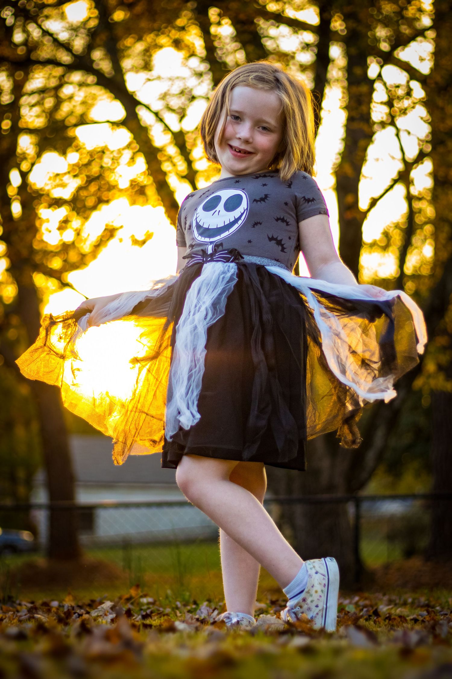 Cute young girl posing in Halloween dress during golden hour in the fall. Portrait taken by Chris Suits Photography