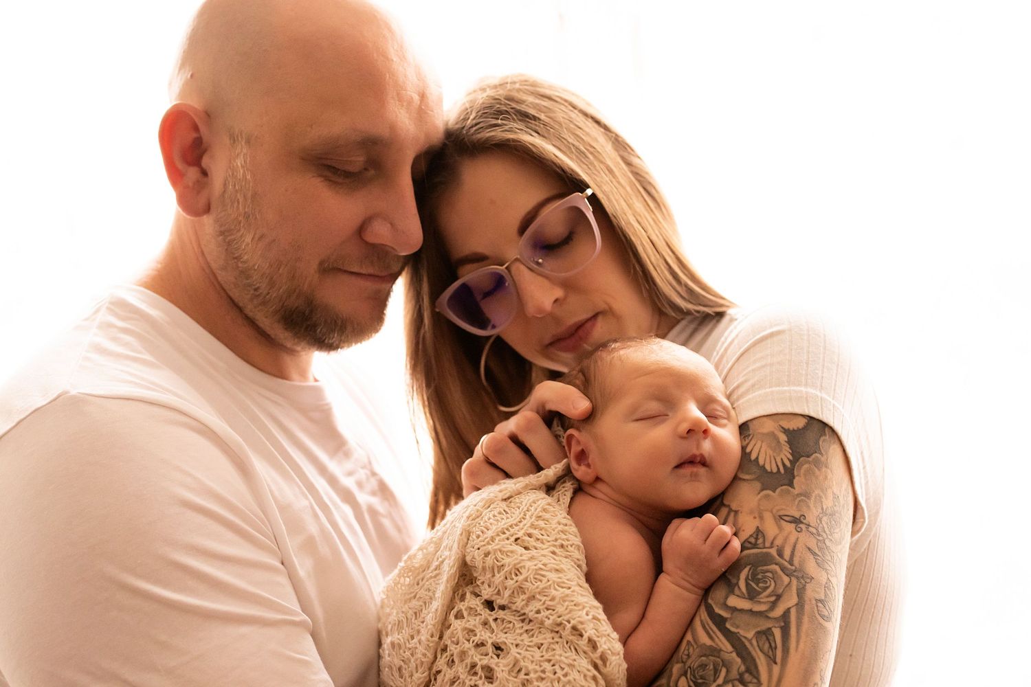 Studio family portrait session with soft lighting showcasing tender embraces.