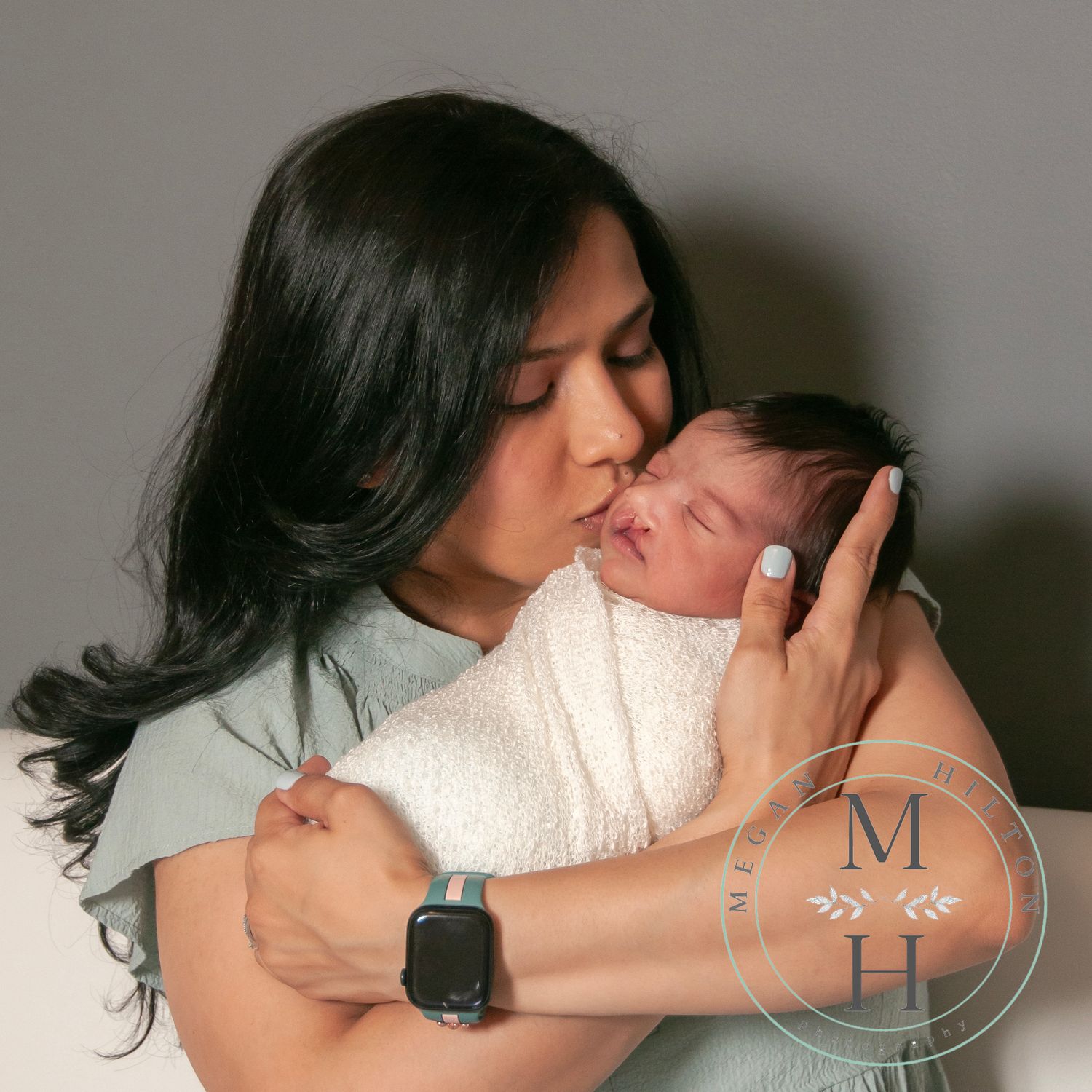 mom kissing newborn son photo