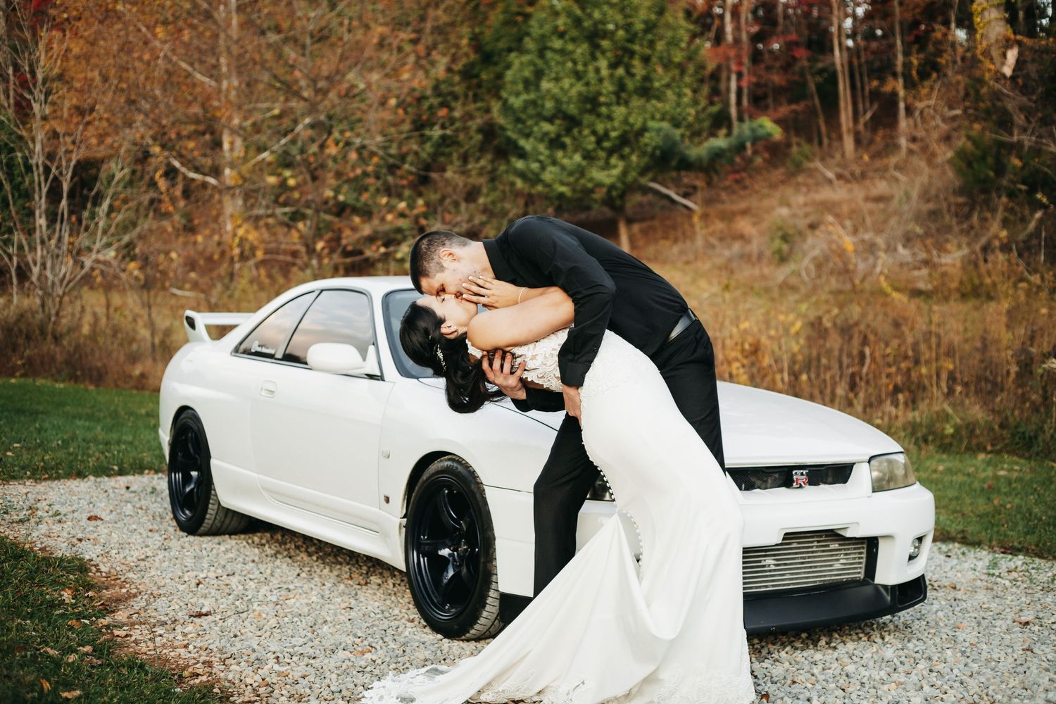 Olivia and Cruise share a deep kiss on their wedding day at Appalachia Hills in Callaway, Virginia. A white sports car in the background.