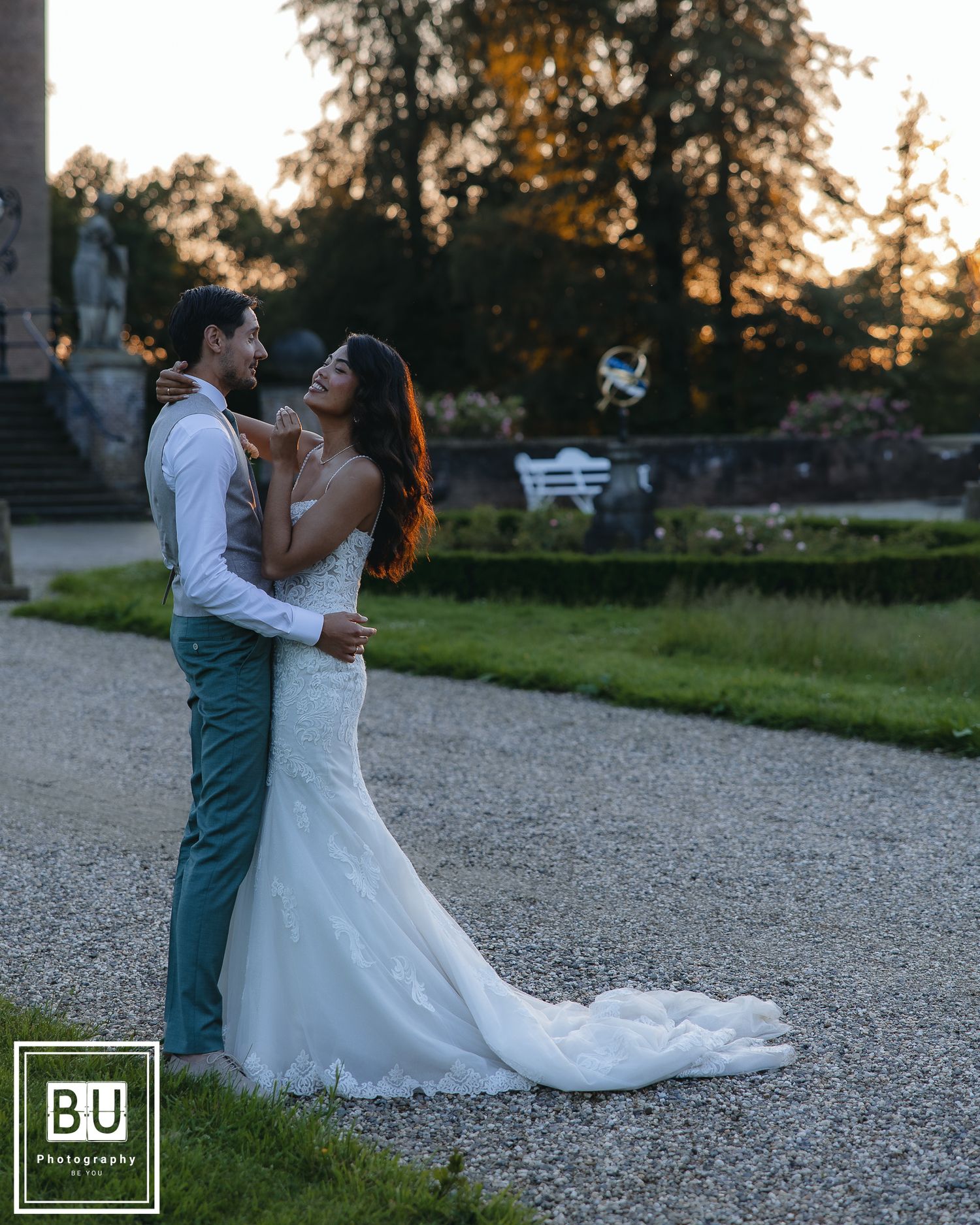 Newlyweds share intimate moment at sunset in garden setting.

- BU Photography -