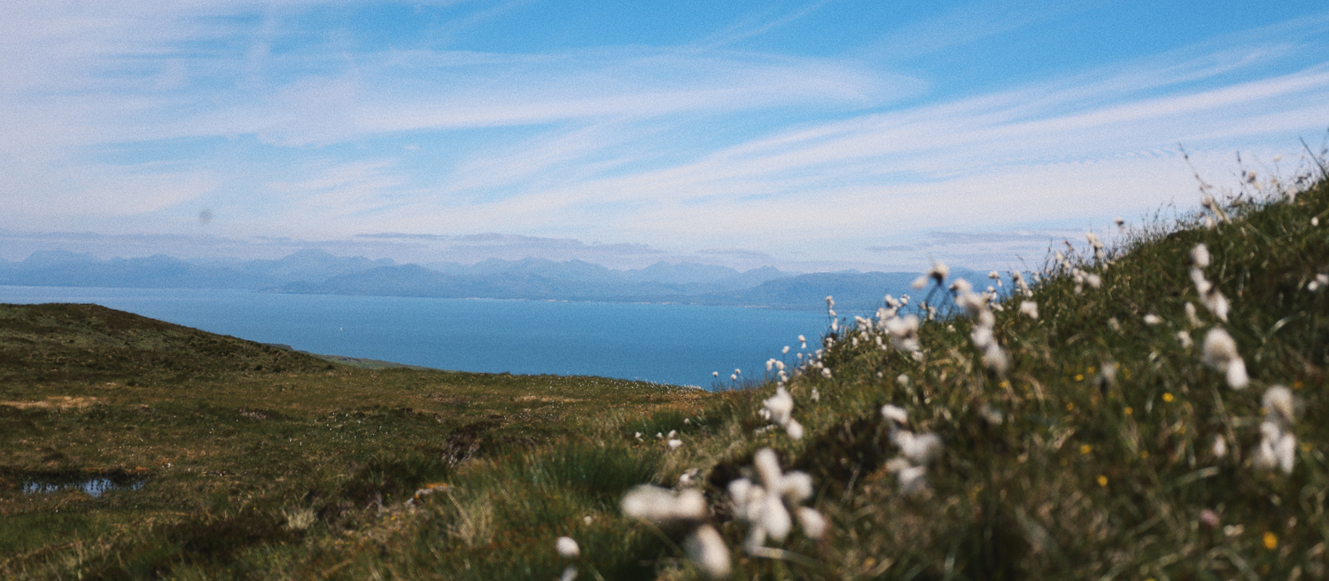 Mountain landscape with vast green hills and blue skies stretching to the horizon.