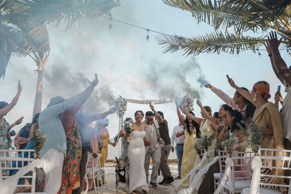 Excited crowd throws powdered color into the air during a festival celebration creating vibrant clouds of blue and white.