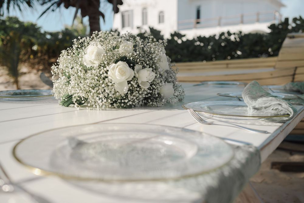 A compilation of elegant table settings featuring white floral arrangements and delicate place settings for a formal event.