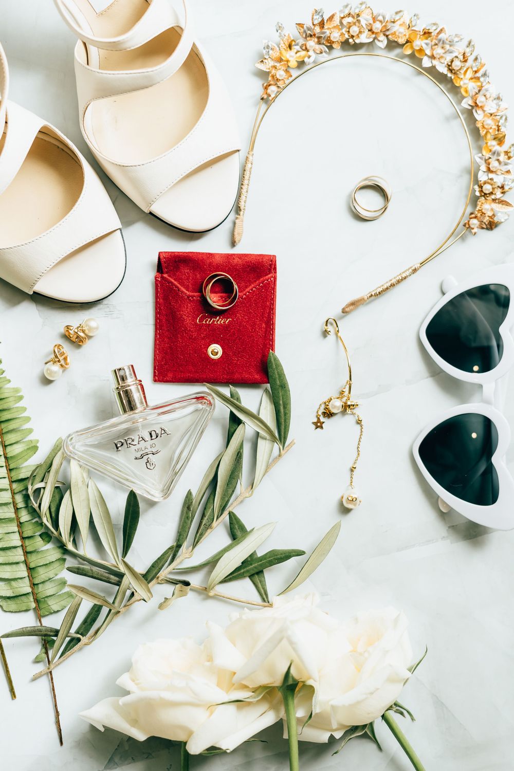 Wedding details flatlay with rings, shoes, white roses and gold accessories on light background, Blue Venado, Mango Weddings.