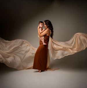 Artistic portrait series with flowing peach fabric against a dark background.