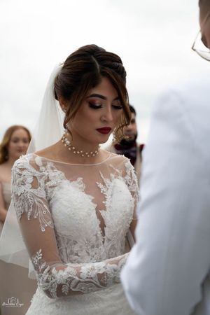 Bride wearing intricate lace wedding gown with sheer details.