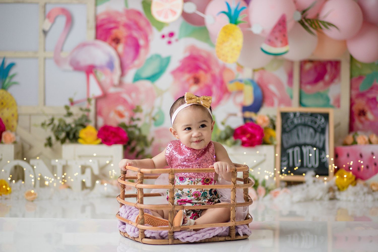 Tropical themed birthday setup with flamingo wall art and wooden props.