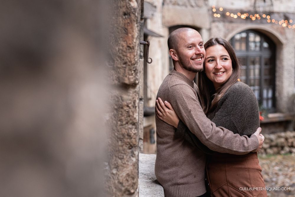 Romantic moment captured against weathered brick wall and vintage architecture.