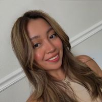 A selfie portrait showing off long layered caramel-colored hair and a warm smile.