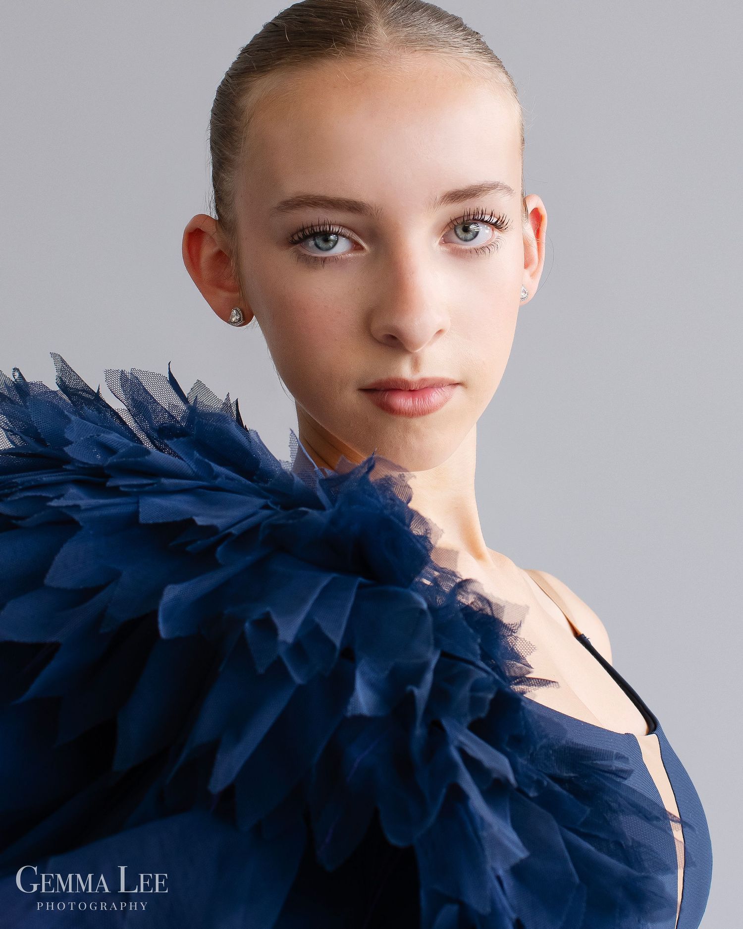 Dance\ Ballet portrait featuring dramatic navy blue feathered haute couture attire captured in elegant natural lighting.