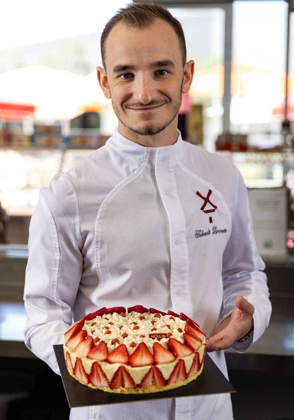 Southern California pastry chef presenting a strawberry and vanilla dessert in his pastry kitchen while being captured by food photographer.