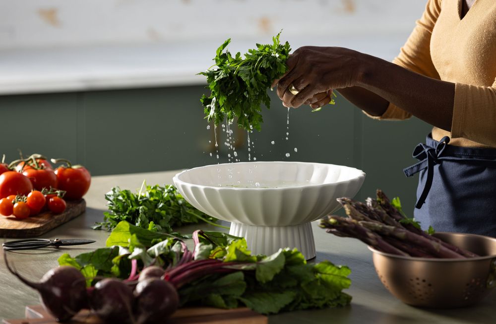 Lifestyle photograph of a woman prepping some produce to be cooked in Los Angeles photography studio kitchen.