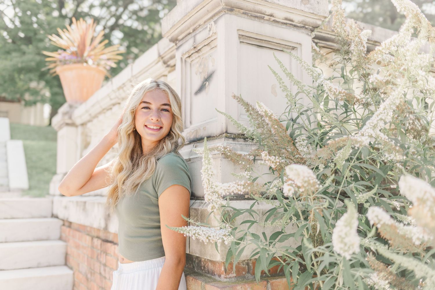 Senior girl posing in a Hudson Valley, NY garden during her summer senior portrait session