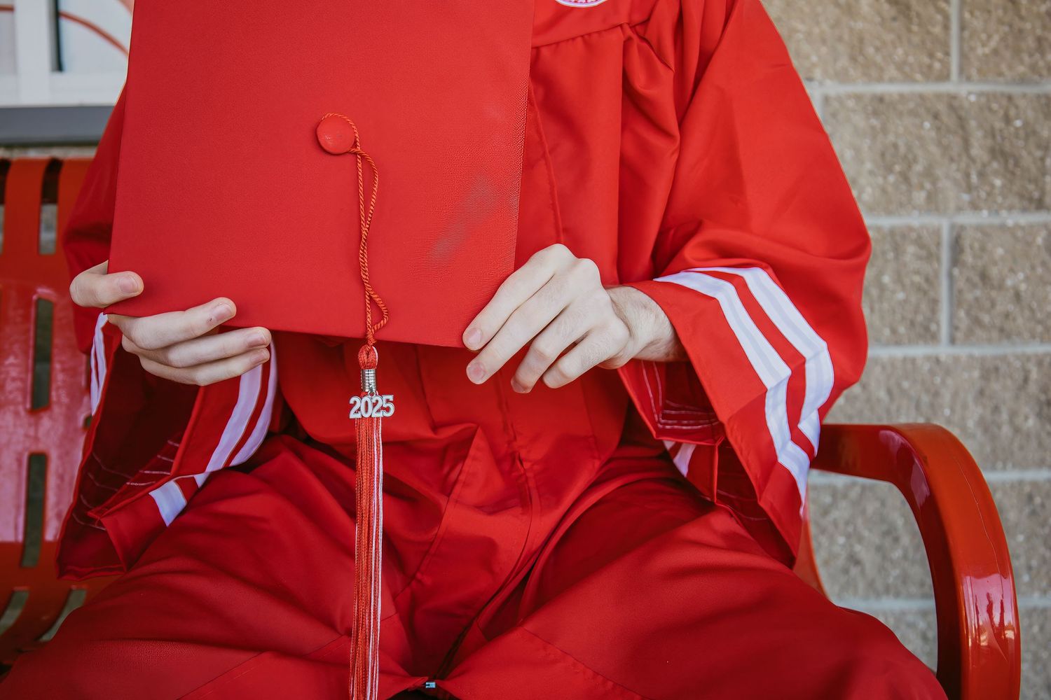 Close-up of graduation tassel and red gown details during commencement ceremony.