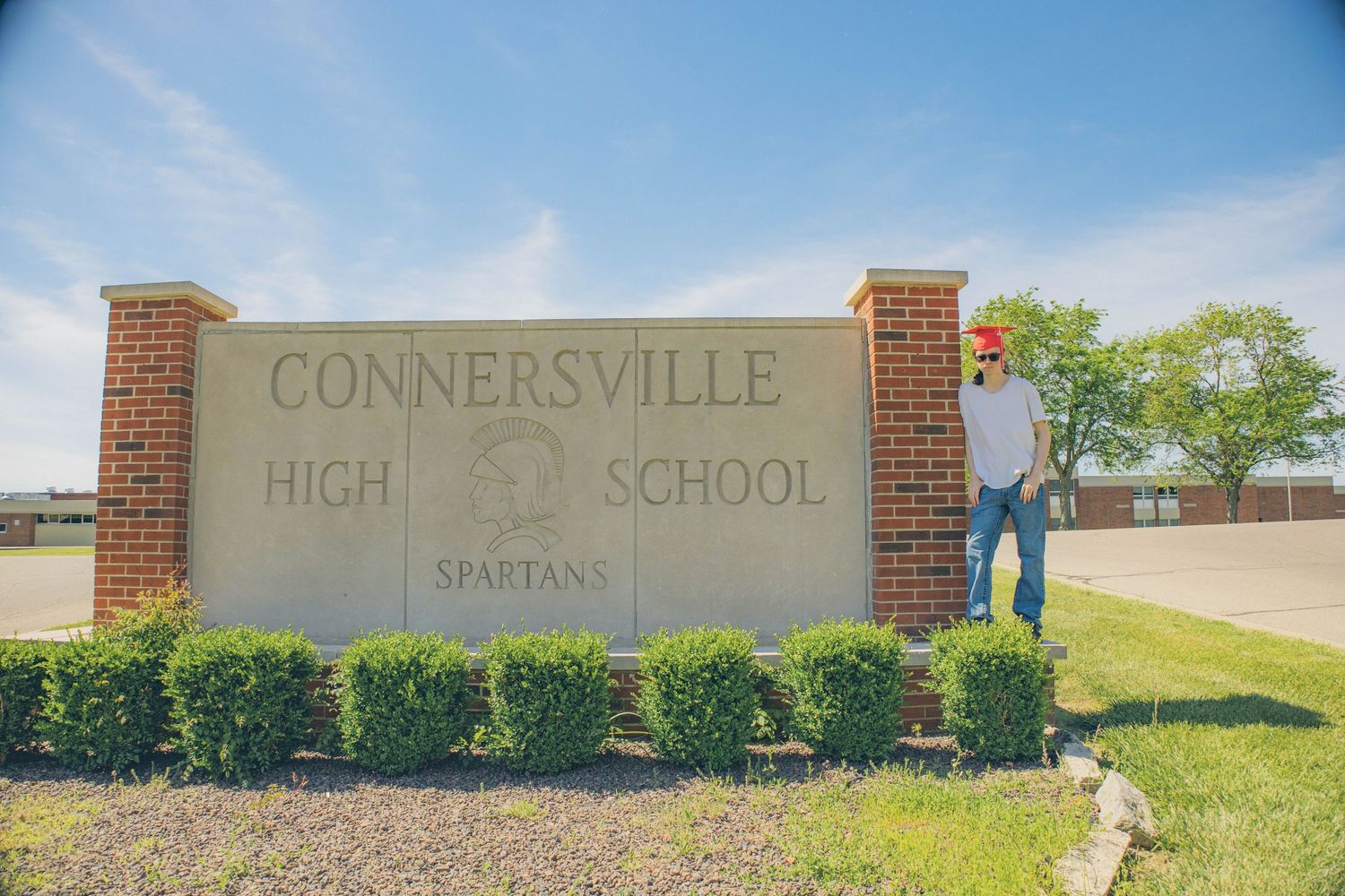 Connersville High School entrance sign with brick columns and landscaping.