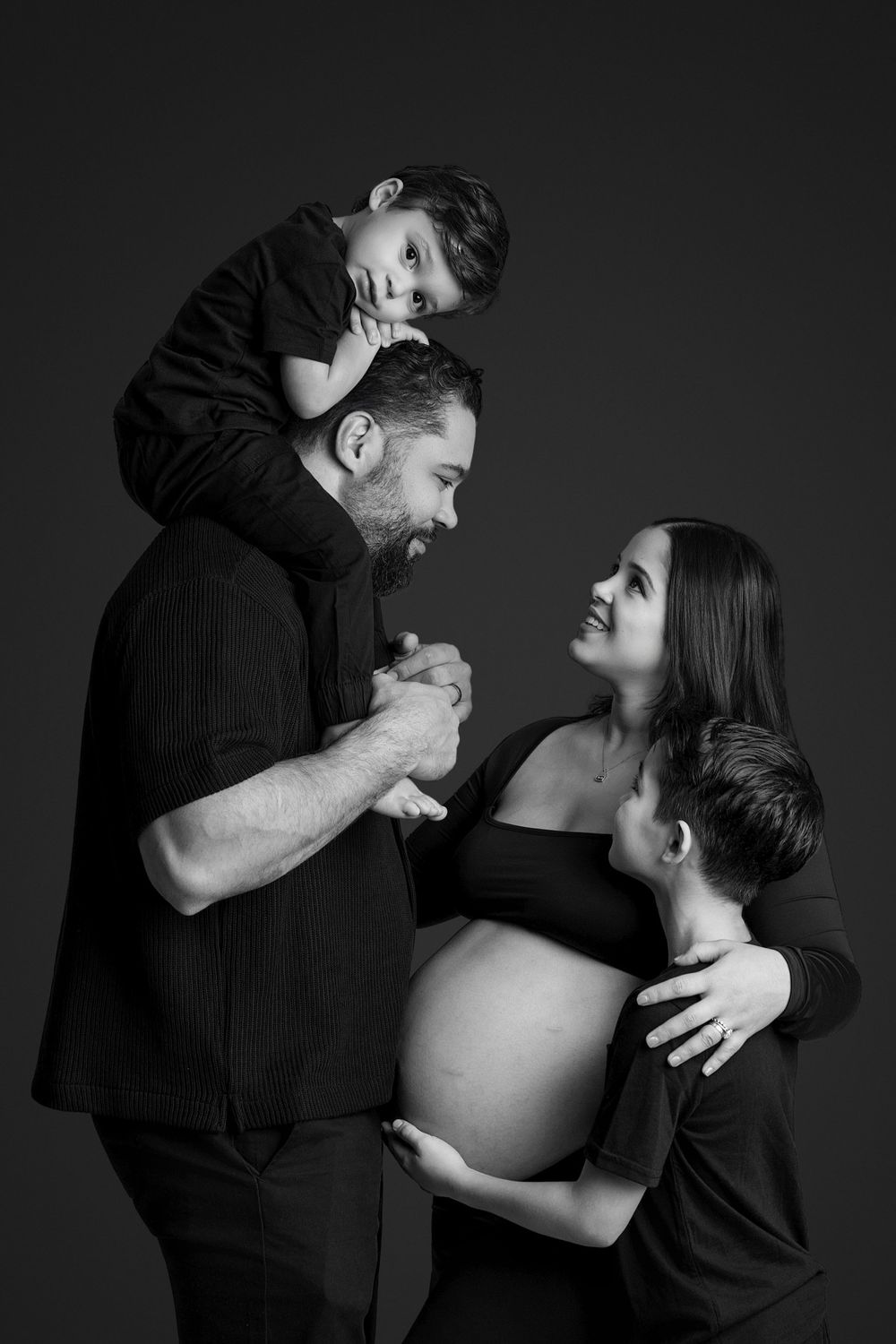 Black and white maternity photo series capturing intimate moments between expectant couple.