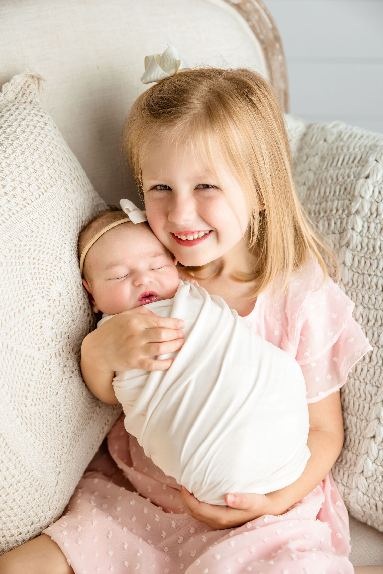 Newborn wrapped in white with sister sibling sitting in chair.  Middle TN Newborn Photographer.