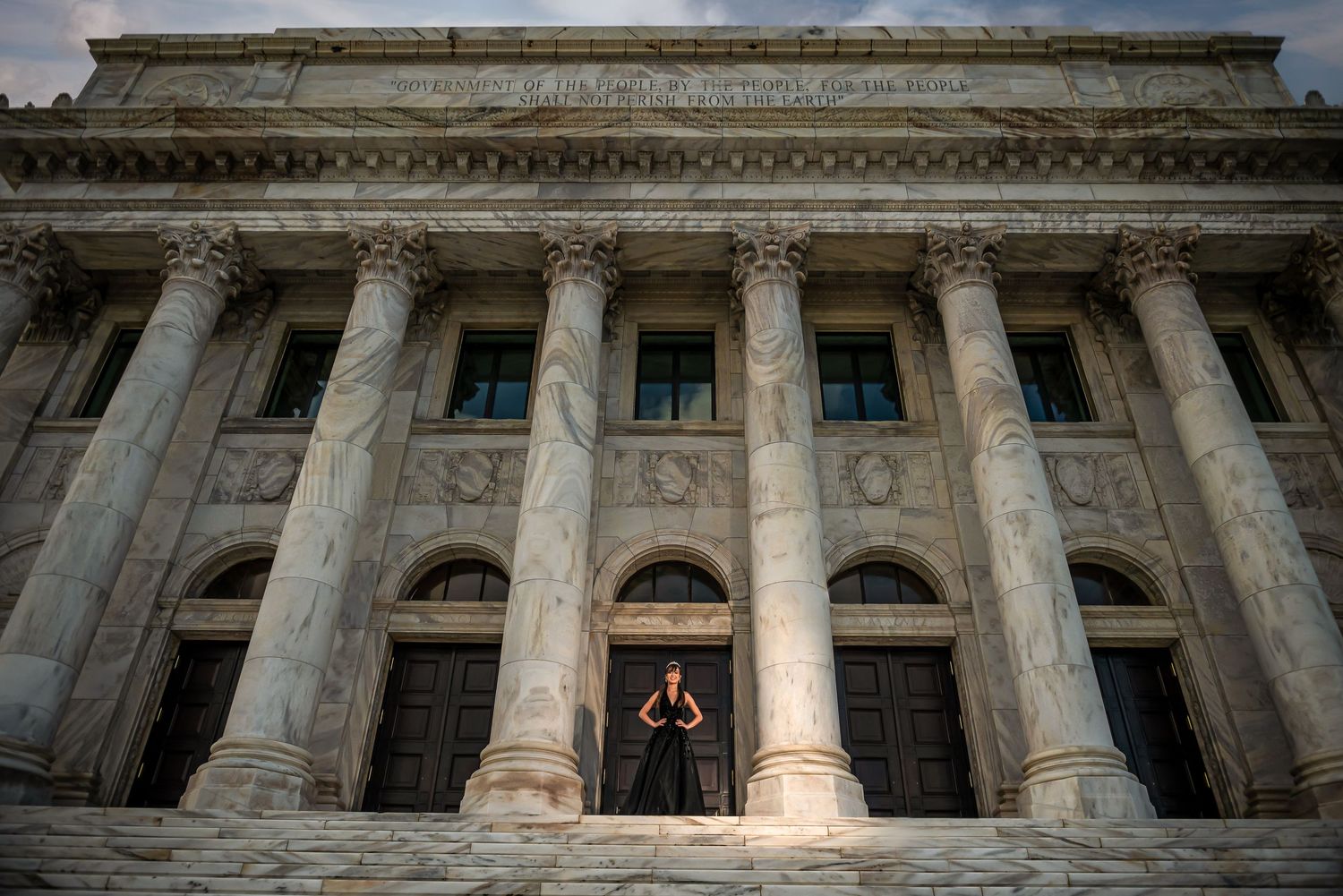 A dramatic architectural photograph of a grand neoclassical building with tall columns at dusk.