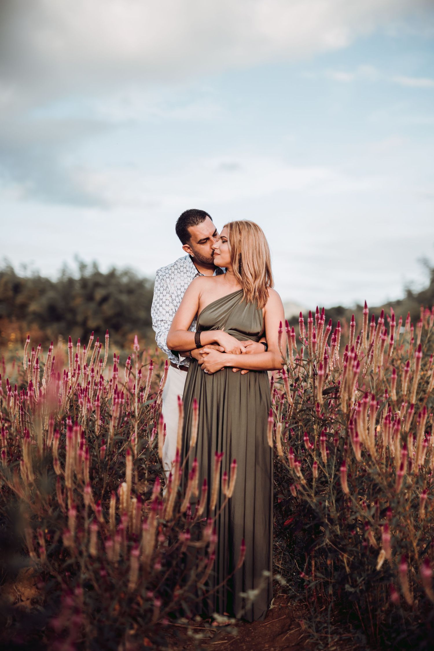 Intimate portrait in a field of purple wildflowers during golden hour.