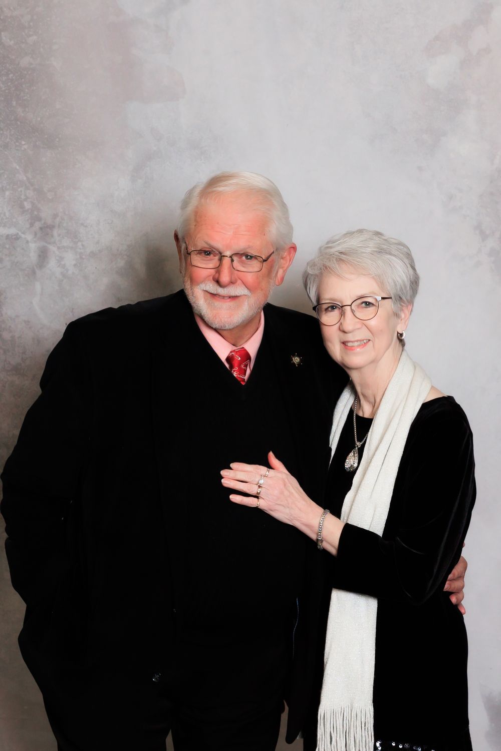 An elegant senior couple poses for a portrait in formal black and white attire.