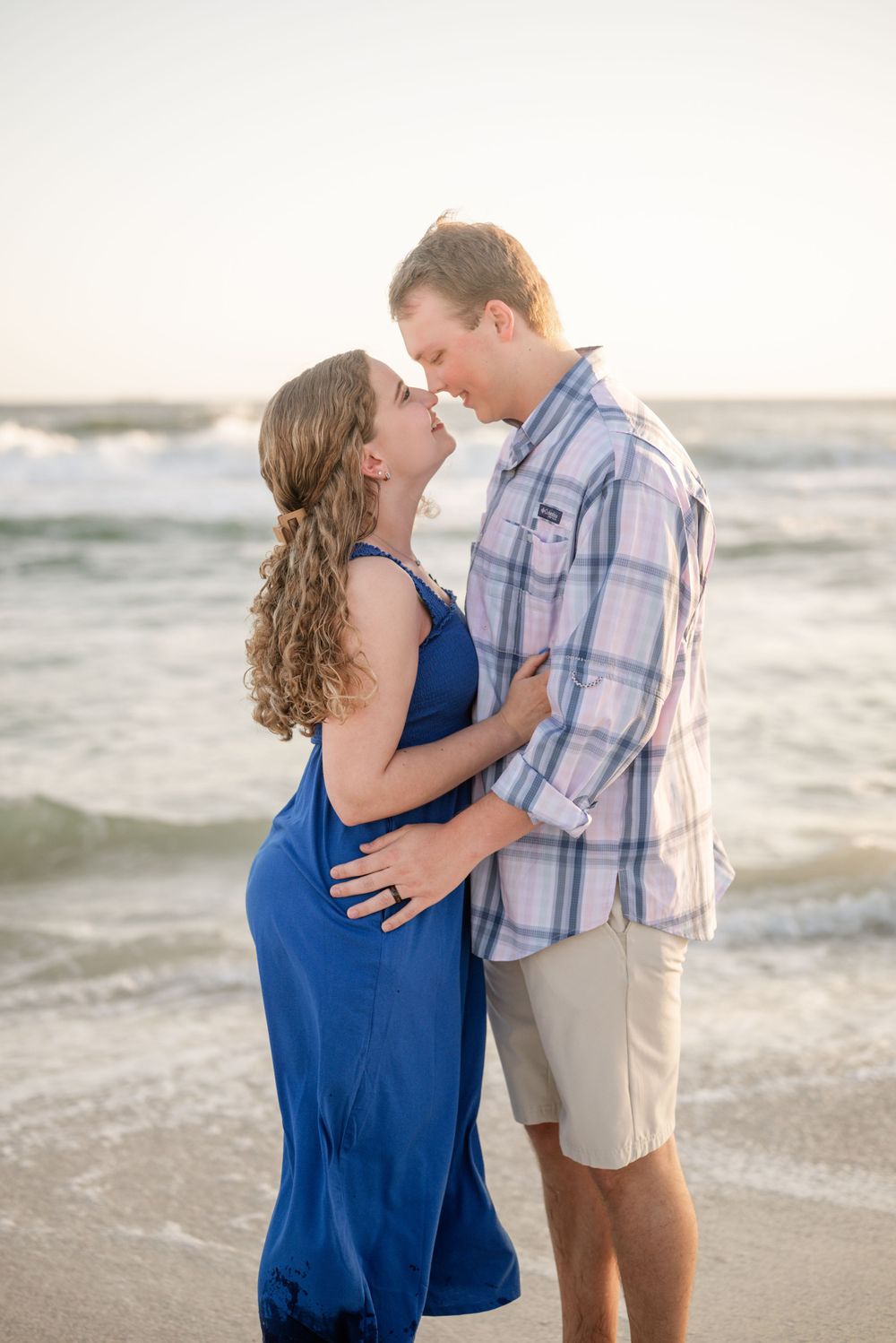Intimate beach portrait of couple in blue dress and plaid shirt.