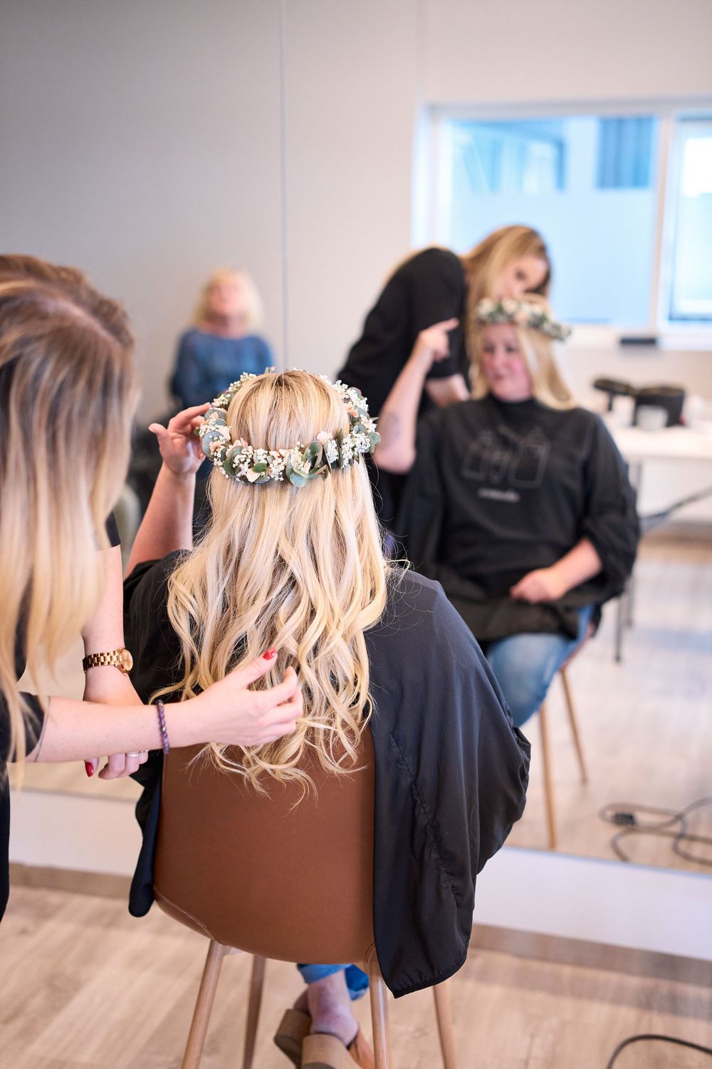 Wedding preparation scene with hair styling in a modern salon setting.