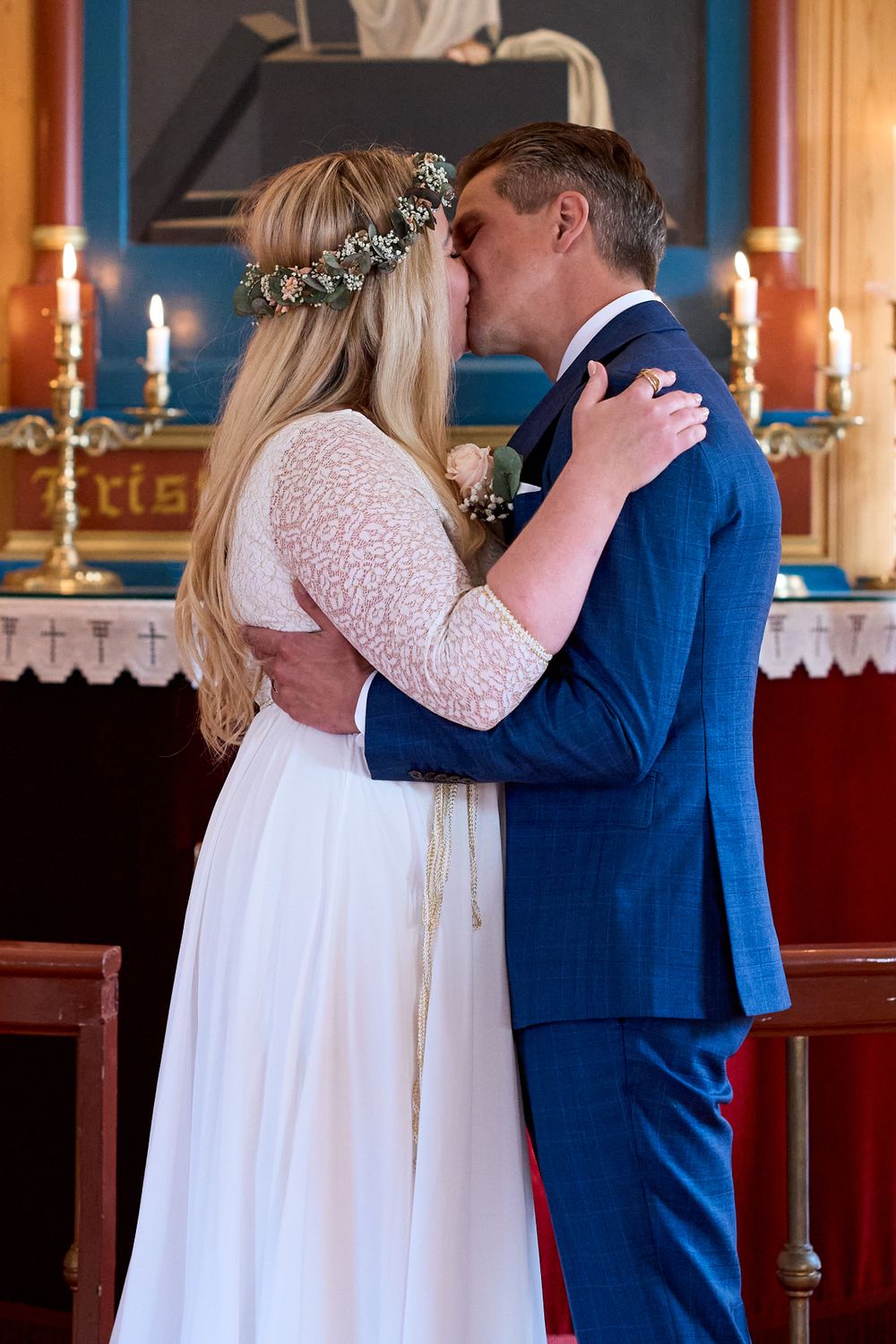 A romantic moment captured between newlyweds in a traditional church setting with candlelit ambiance.