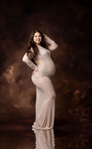 Ethereal maternity photography session with sparkly dress against moody brown backdrop.