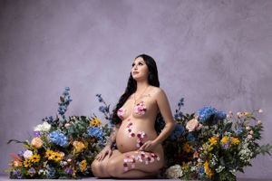Floral maternity photography with colorful blooms and soft natural styling.