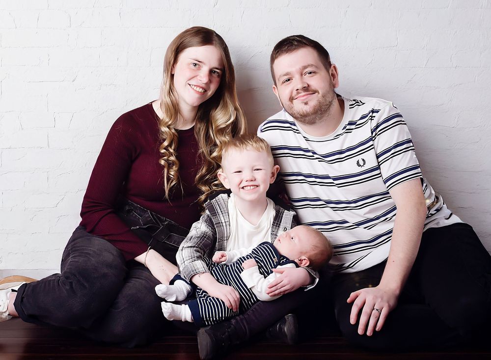 Family introducing newborn in a warm studio session by Nicola in Woodside, capturing natural, emotional moments and timeless newborn connect