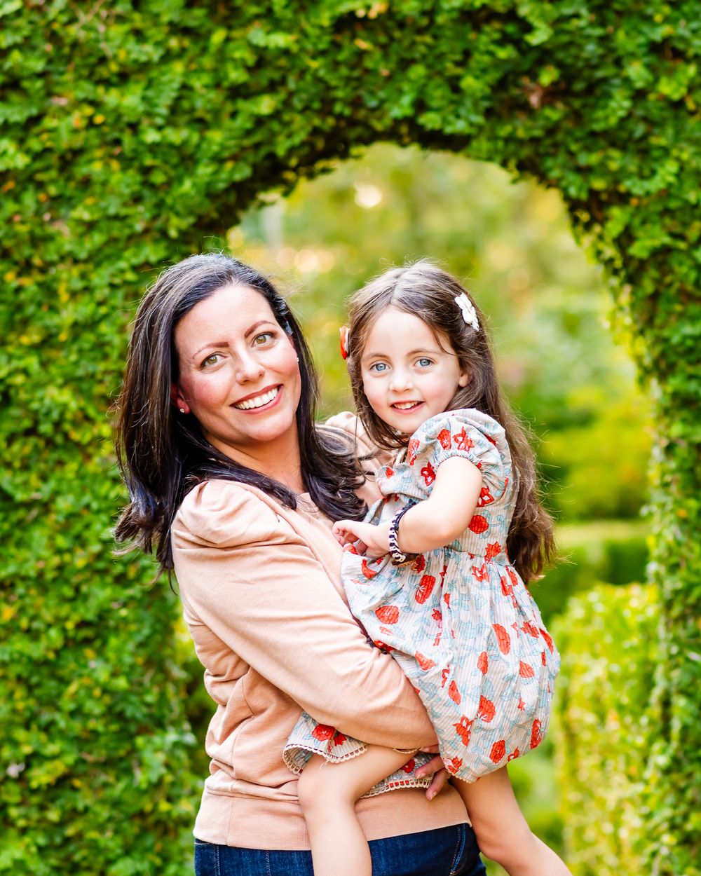 A joyful embrace between two people in a lush green garden setting on a sunny day.