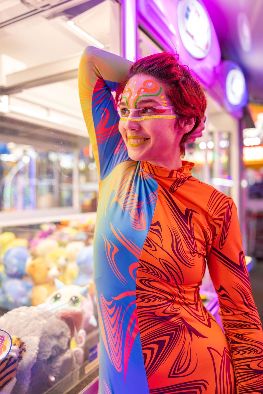 Vibrant portrait with orange bodysuit and face paint against neon lights at carnival.