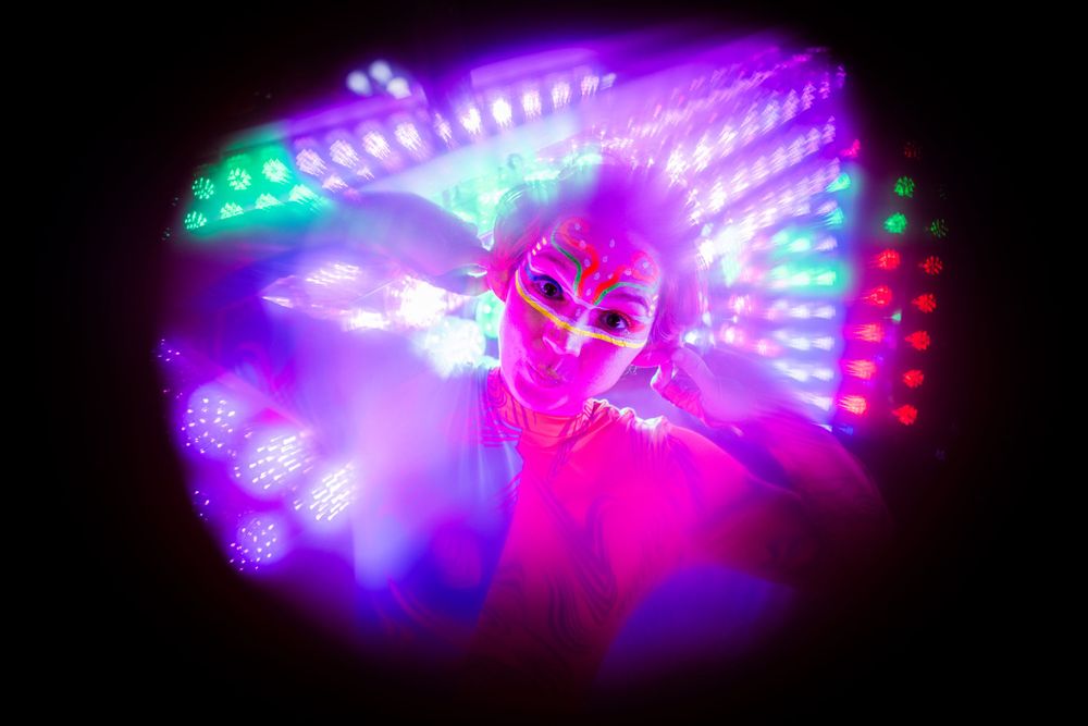 Abstract neon light pattern creating a vibrant pink and purple spiral effect in darkness.
