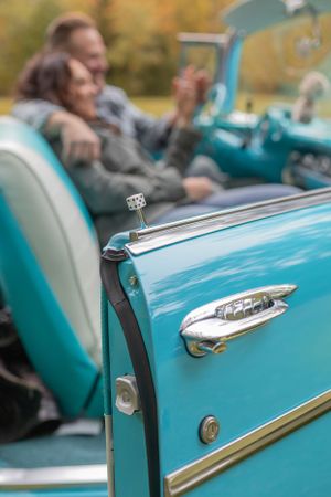 Detail shot of a turquoise classic Chevrolet's chrome trim and door handle.