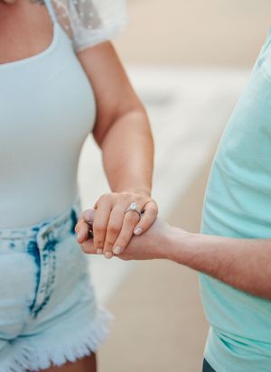 Close-up of hands with engagement ring showing a romantic moment between a couple.