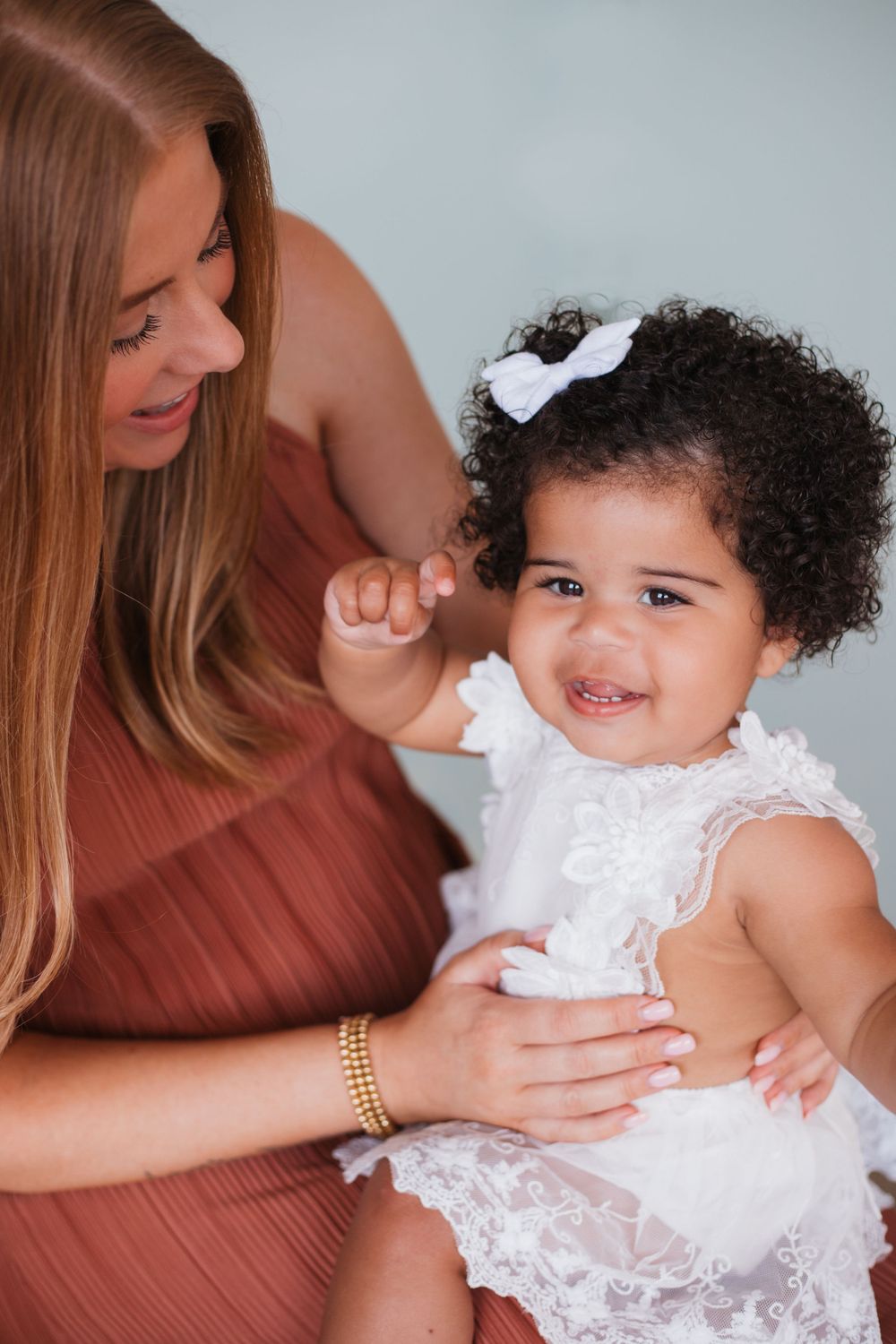 A sweet candid moment captured between adult and child against a light background.