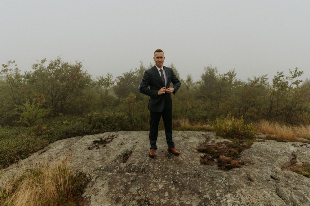 artistically Alexia photography m and j elopement groom buttoning jacket