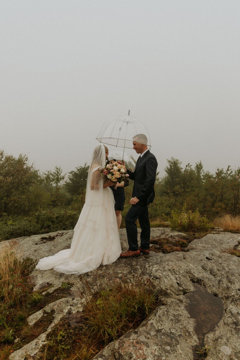 artistically Alexia photography m and j elopement bride and groom with umbrella in rain