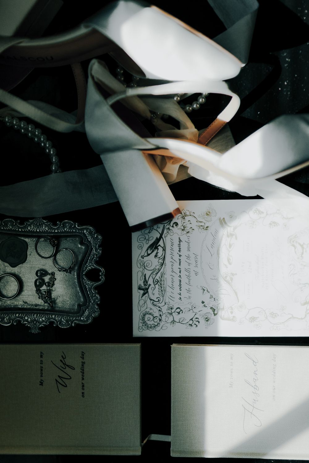 Wedding stationery and invitations with decorative details captured in dramatic lighting.