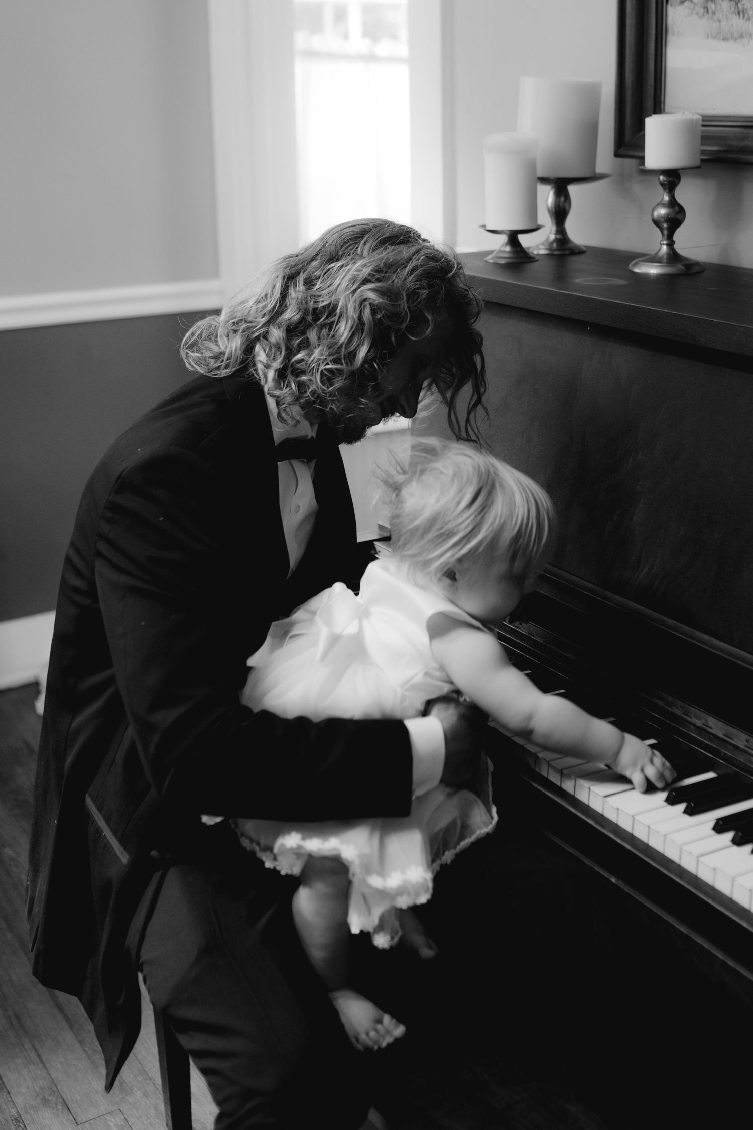 A romantic scene with a couple dancing near a piano in black and white.