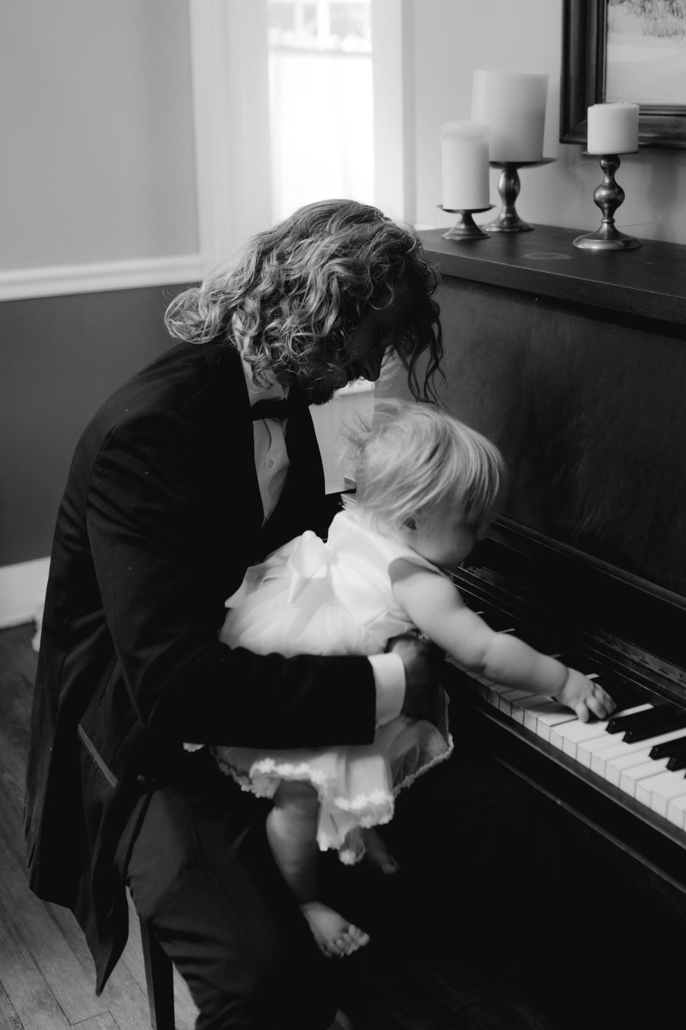 A romantic scene with a couple dancing near a piano in black and white.